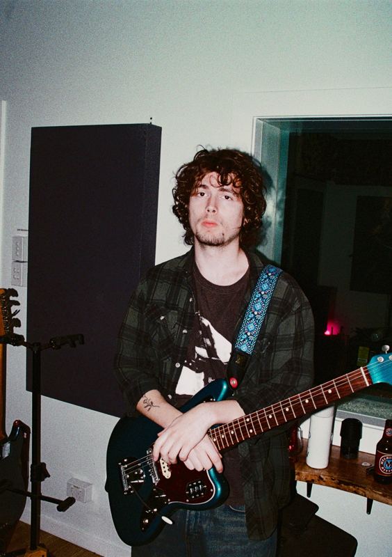 Aodhan in the studio: guitarist holding a teal electric guitar