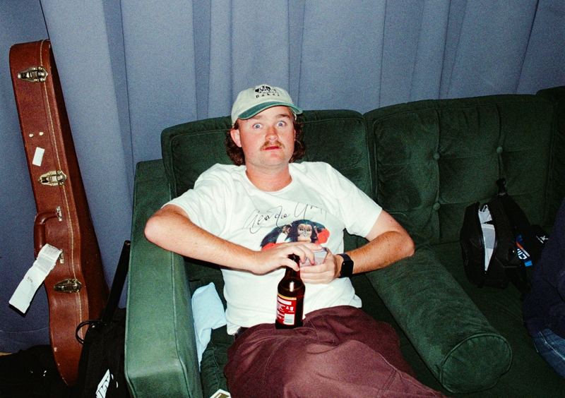 Aodhan in the studio: relaxing on the green studio couch with a drink
