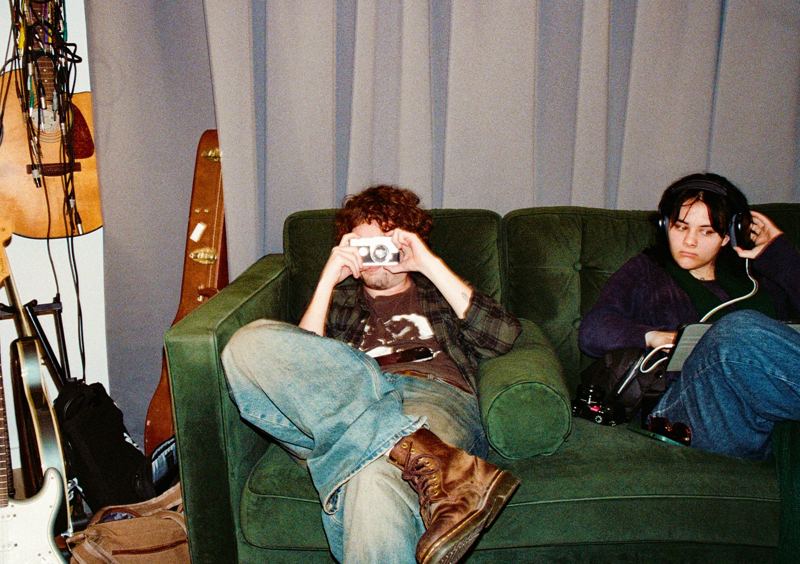 Aodhan in the studio: on the studio couch, taking a photo back at the camera