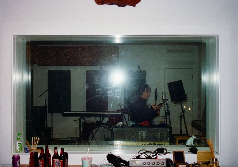 Aodhan in the studio: looking through the control room window into the live room