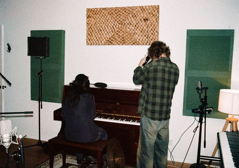 Aodhan in the studio: two people at the upright piano in the live room